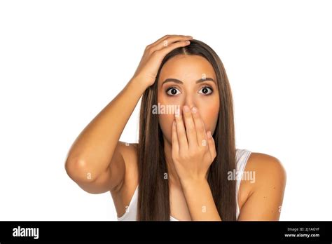 Shocked Young Woman Covers Her Mouth With Her Hand On A White