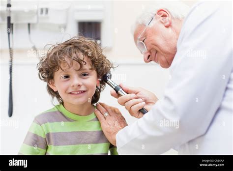 Doctor Examining Boy In Office Stock Photo Alamy