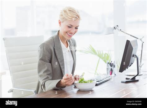 Businesswoman Eating Salad On Her Desk Stock Photo Alamy