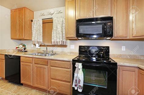 Glidden whispering wheat is a great choice for kitchens with traditional oak cabinets and dark granite countertops. 6 Elegant Kitchens With Black Appliances And Oak Cabinets ...