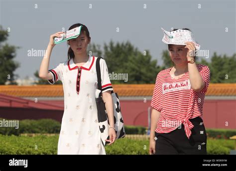 Tourists Sheilding Themselves With Flyers From The Scorching Sun As