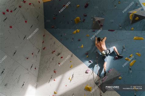 Shirtless Man Climbing On The Wall In Climbing Gym — Determination