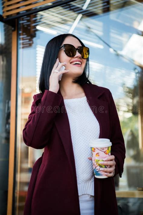 Young Brunette Drinking Coffee Walking Around The City Wearing Coat