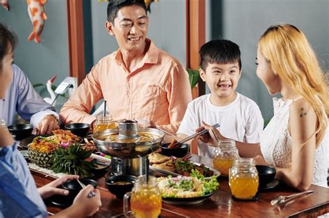 Familia Disfrutando De La Cocina Asiática En La Cena Foto Premium