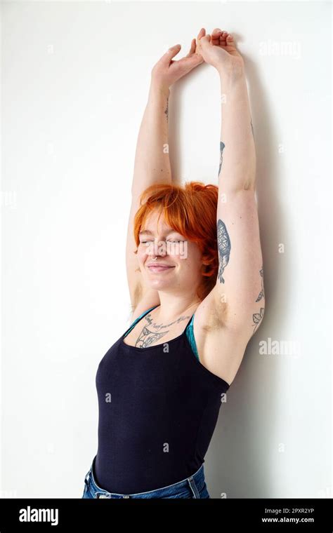 A Beautiful Woman In Her Mid Twenties With Tattoos And Unshaved Armpits With Her Arms Raised