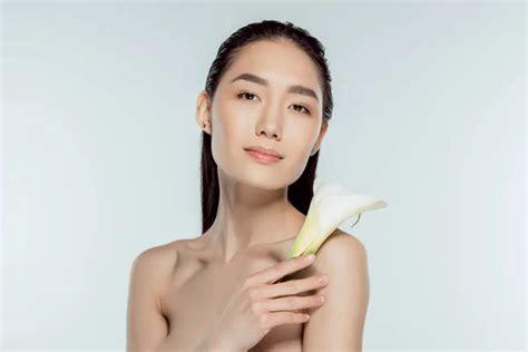 beautiful nude asian girl posing with calla flower isolated on grey — flora trend stock