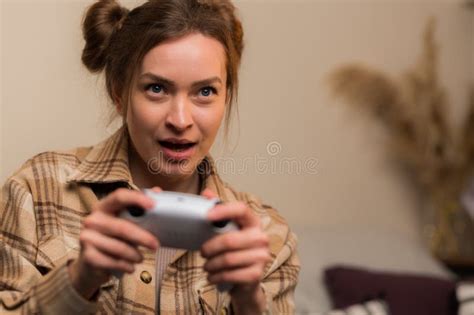 close up attractive blonde with a gamepad in her hands plays a video game focused facial