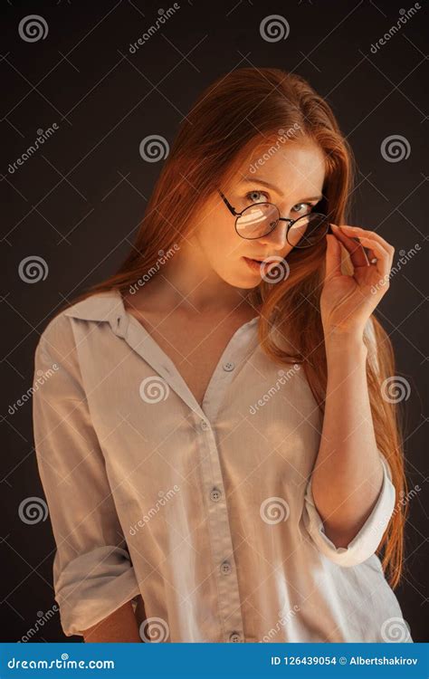 Redhead Female Model In Glasses Posing On Black Background Stock Photo