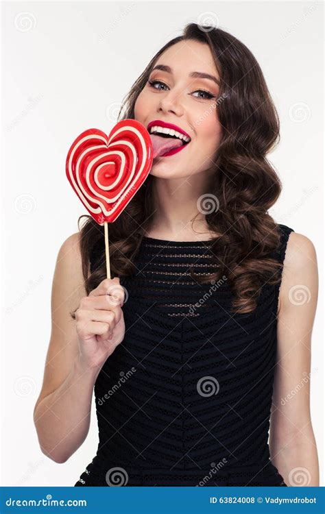Content Woman With Retro Hairstyle Licking Bright Heart Shaped Lollipop