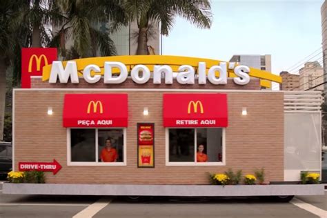 Bright yellow and red mcdonalds drive thru sign at a local mcdonalds standing in front of the mcdonalds. McDonald's Drive-Thru Actually Drives Up To Diners