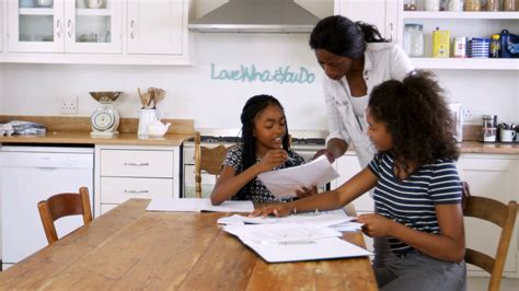 Mother Helping Two Daughters Sitting At Stock Footage Sbv 316627616