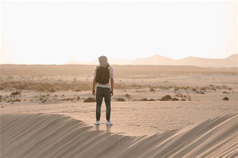 Man Standing Among Many Hot Sand In Desert By Stocksy Contributor