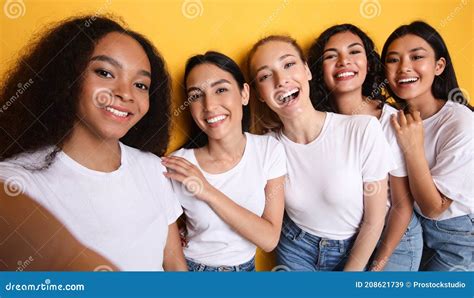 Group Of Five Women Making Selfie Standing Over Yellow Background Stock