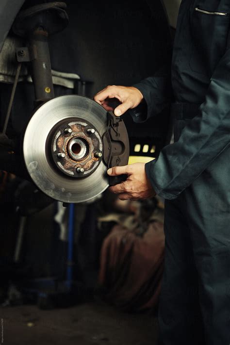Mechanic Fixing Brakes By Stocksy Contributor Kkgas Stocksy