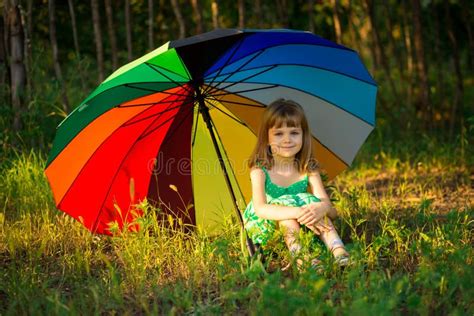 Happy Child Girl Walk With Multicolored Umbrella Under Rain Stock Photo