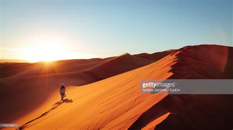 Silhouette Of Woman On Sand Dune In Desert Against Clear Sky Woman