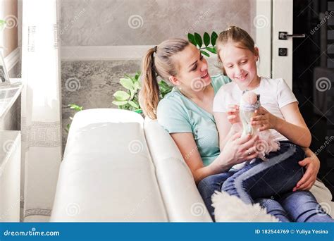 Mother With Her Adult Daughter Sitting Together And Having Good Time In The Living Room In Front