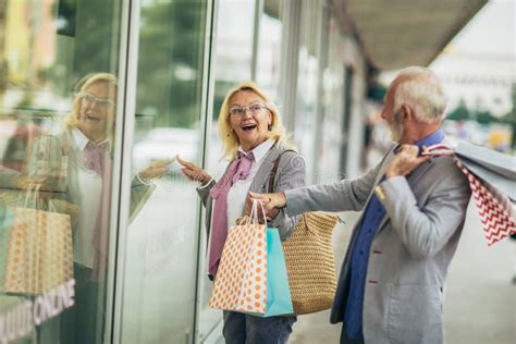 Mature Couple Carrying Shopping Bags And Enjoying To Shopping Stock