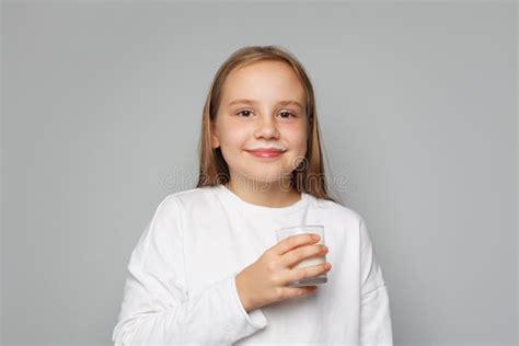 Happy Young Girl Child With Glass Of Milk In Her Hand Smiling And