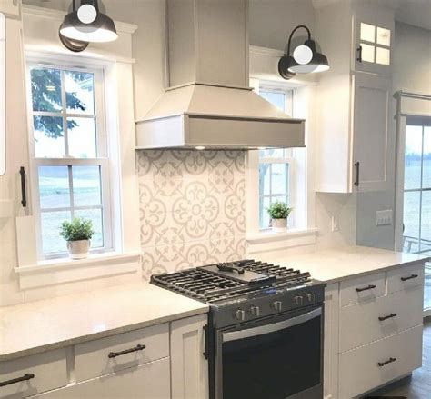 White subway tile is a classic choice for kitchen backsplashes, but dark grout lines give the material a crisp, modern appearance. Custom stove hood with ceramic tile backsplash between ...
