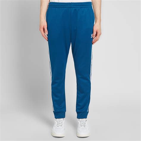 A sporty essential infused with modern spirit. Adidas SST Track Pant Legend Marine | END.