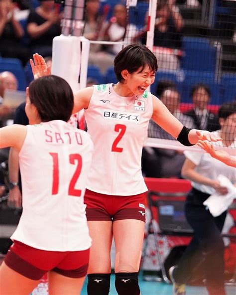 Two Women Playing Volleyball In Front Of An Audience