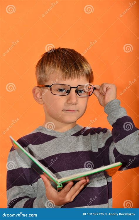 Portrait Of A Boy In Glasses With A Book In His Hands Cheerful