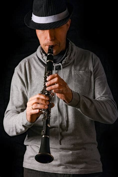 Clarinet In The Hands Of A Man On A Black Background Stock Photo