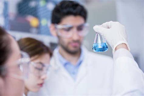 lab assistants looking at flask photograph by science photo library fine art america