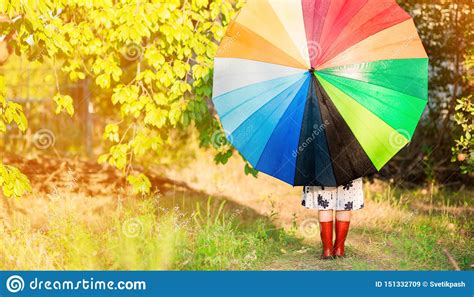Happy Child Girl Walk With Multicolored Umbrella Under