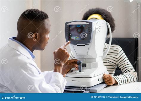 Optician Doing Optometry Eye Exam Of Black African American Teen Girl