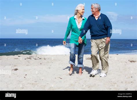 Senior Couple Walk Hand In Hand Into The Sea Hi Res Stock Photography