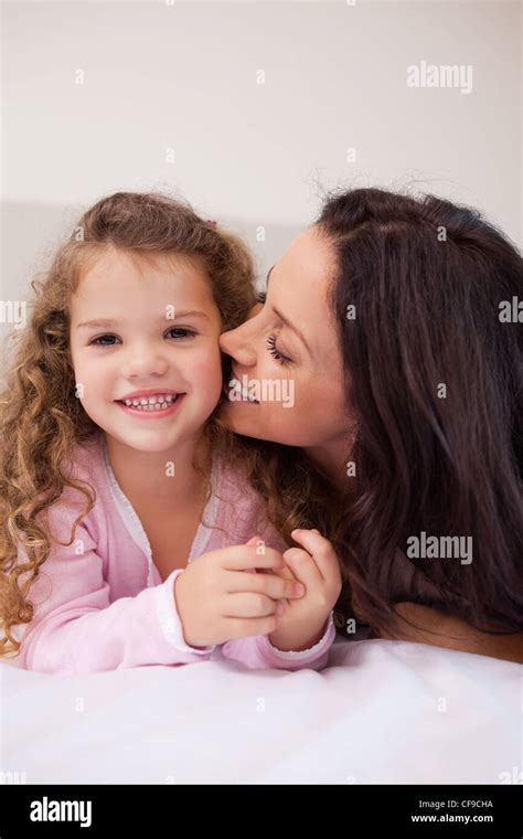 Mother Kissing Her Daughters Cheek Stock Photo Alamy