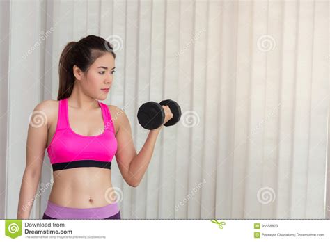 Woman Working Out Shoulders With Dumbbell Training In Fitness Center