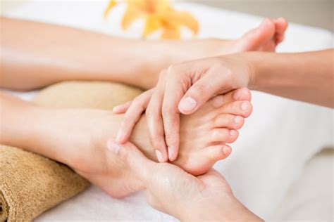 Premium Photo Therapist Giving Relaxing Traditional Reflexology Foot Massage To A Woman In Spa
