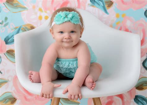 Professional Baby Portriat Of Girl In Bucket Chair On Floral Backgournd