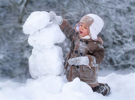 Niños Felices Jugando En La Nieve En Invierno Foto Premium