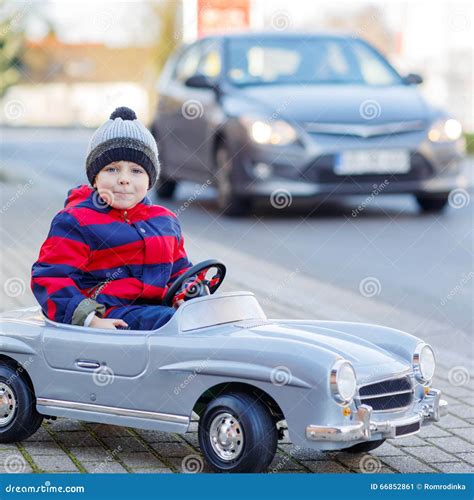 Little Boy Driving Big Toy Car And Having Fun Outdoors Stock Image
