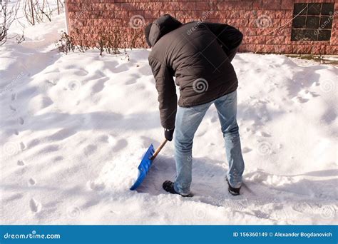 A Teenager Shoveling Snow In His Yard The Concept Of A Snowy Winter
