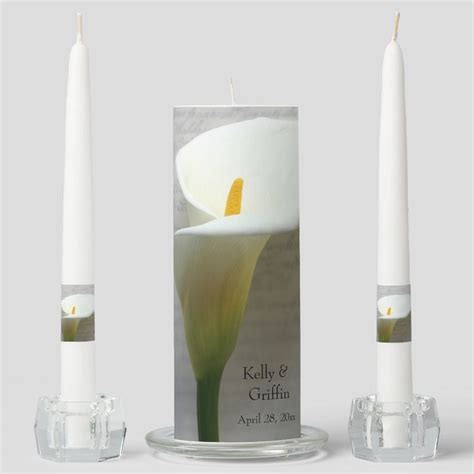 Two White Candles Sitting Next To Each Other