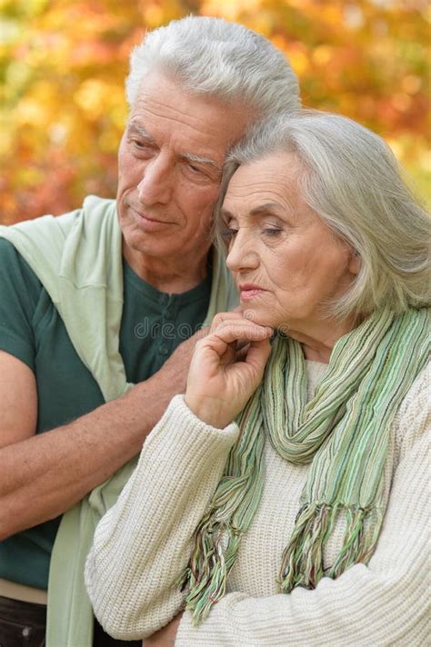 Sad Elderly Couple Standing Embracing Outdoors Stock Image Image Of