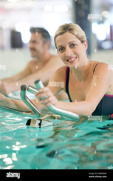 Couple In Swimming Pool Doing Aquabike Exercises Stock Photo Alamy