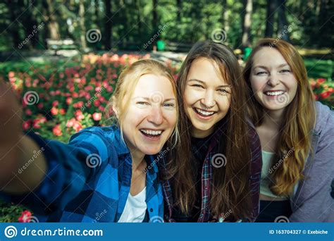 De Jolies Jeunes Filles S Amusent Rire Et Prendre Des Selfies Sur Un Smartphone Dans Le Parc