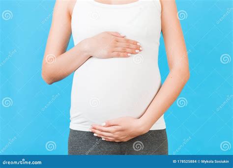 Cropped Image Of Pregnant Woman In Home Clothing Embracing Her Big