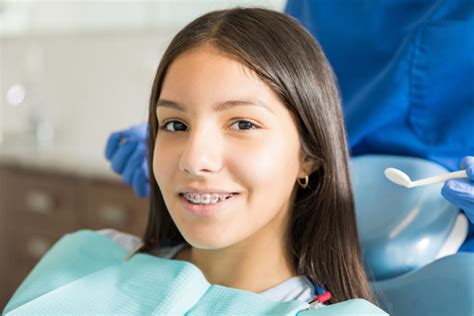 Portrait Of Smiling Teenage Girl With Braces In Clinic Chicago Kidds