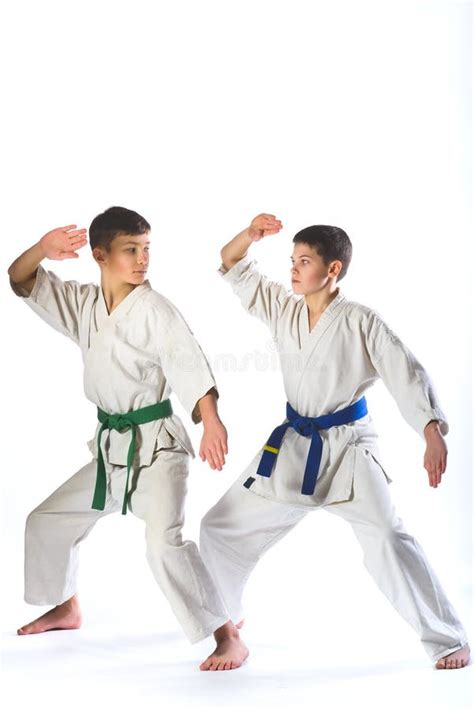 Muchacho Del Karate En Kimono Que Lucha En Un Fondo Blanco Imagen De