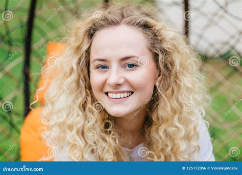 Photo Of Attractive Curly Blonde Female With Shining Smile Shows White Even Teeth Being In