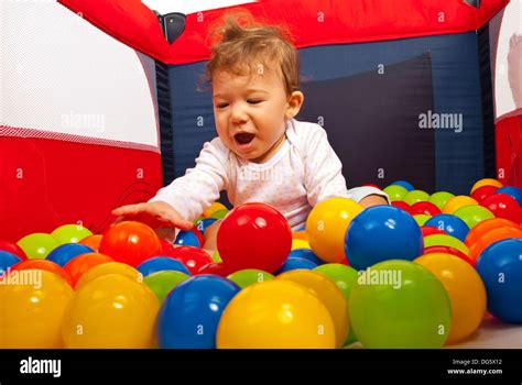Happy Baby Playing With Balls In Playpen Stock Photo Alamy