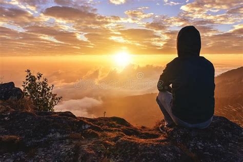 Lonely Man Sitting On A Mountain For Watching Sunrise Views Alone
