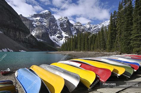Canoe Boats Docked At Moraine Lake In Mountains Of Banff National Park
